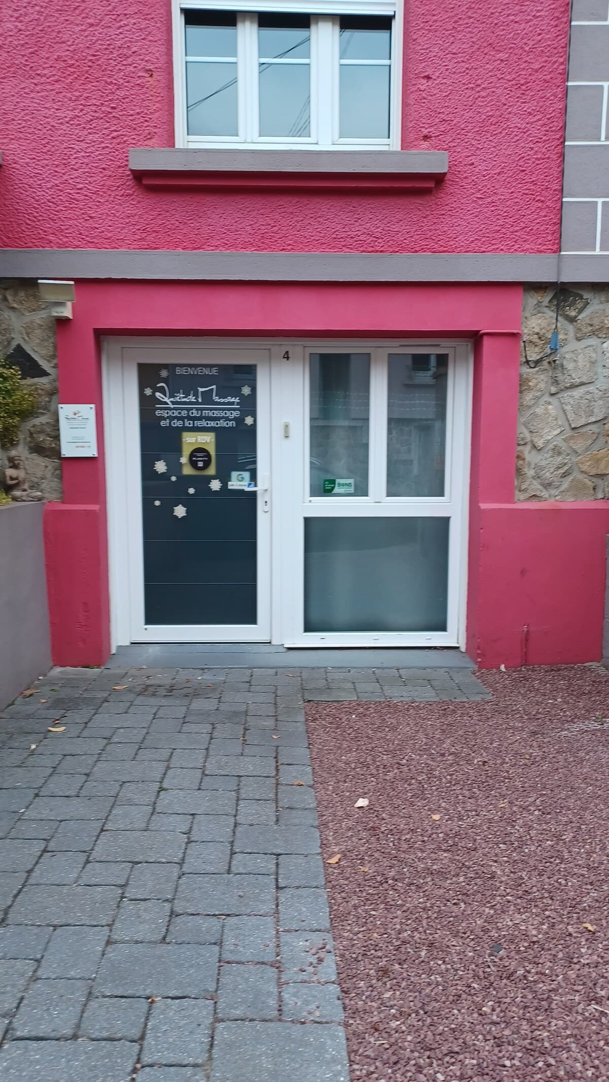 Entrée de Quiétude Massage à Brest, la façade framboise et la porte du cabinet, rue Jules Favre.