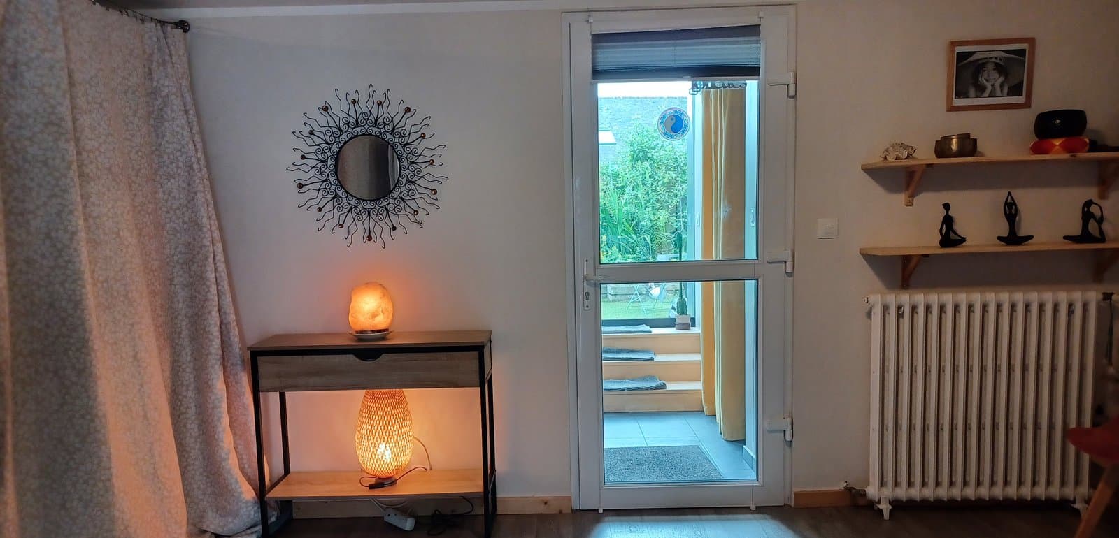 Espace relaxation de Quiétude à Brest, lampe en sel, miroir soleil et accès au jardin.